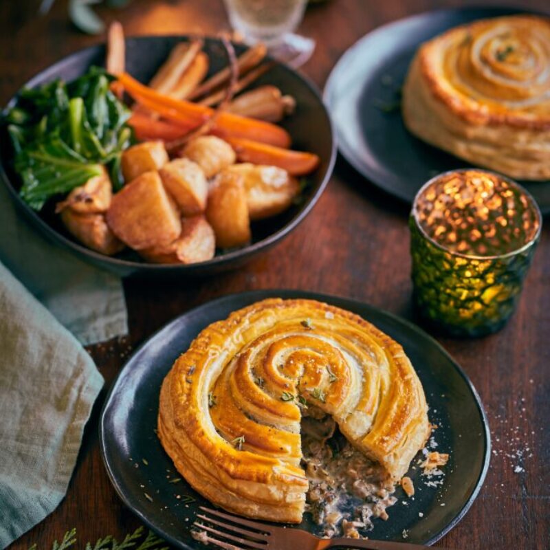 O farfurie acoperită cu o tartă circulară de foietaj cu o garnitură de legume